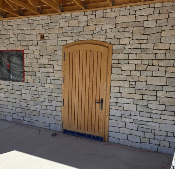 arg-contracting-arrowleaf-arched-wood-door-stone-wall